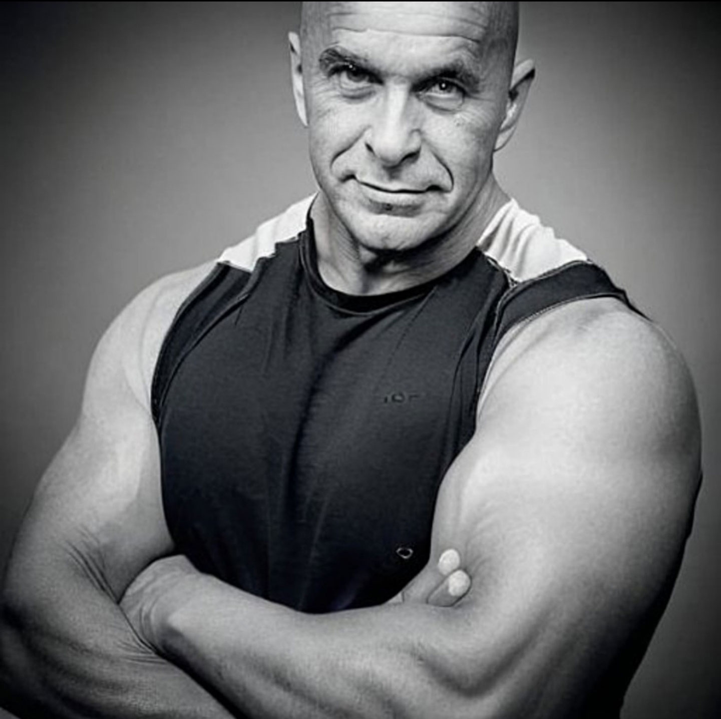Coach posing with his muscles tightened in black and white.